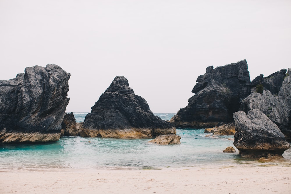 gray rock formations on body of water