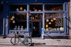 Storefront with clean windows, a black bicycle parked on sidewalk.