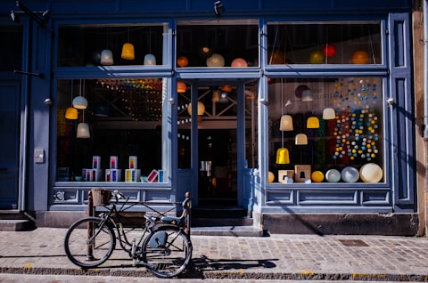 Storefront with clean windows, a black bicycle parked on sidewalk.