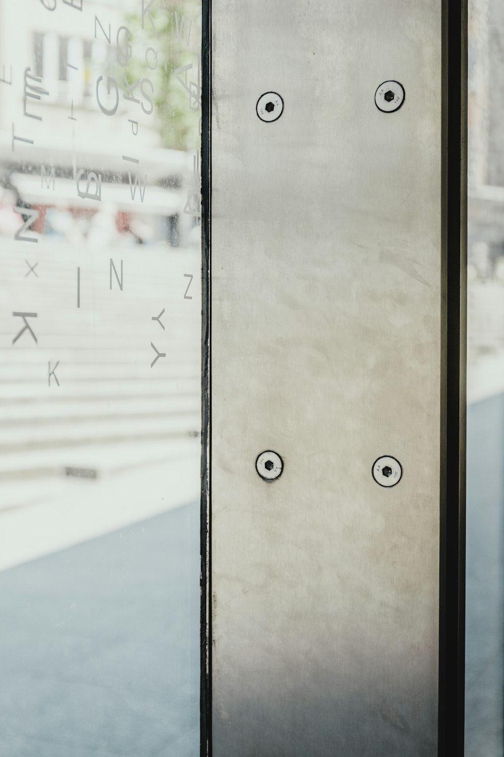 a close up of a metal door with a building in the background