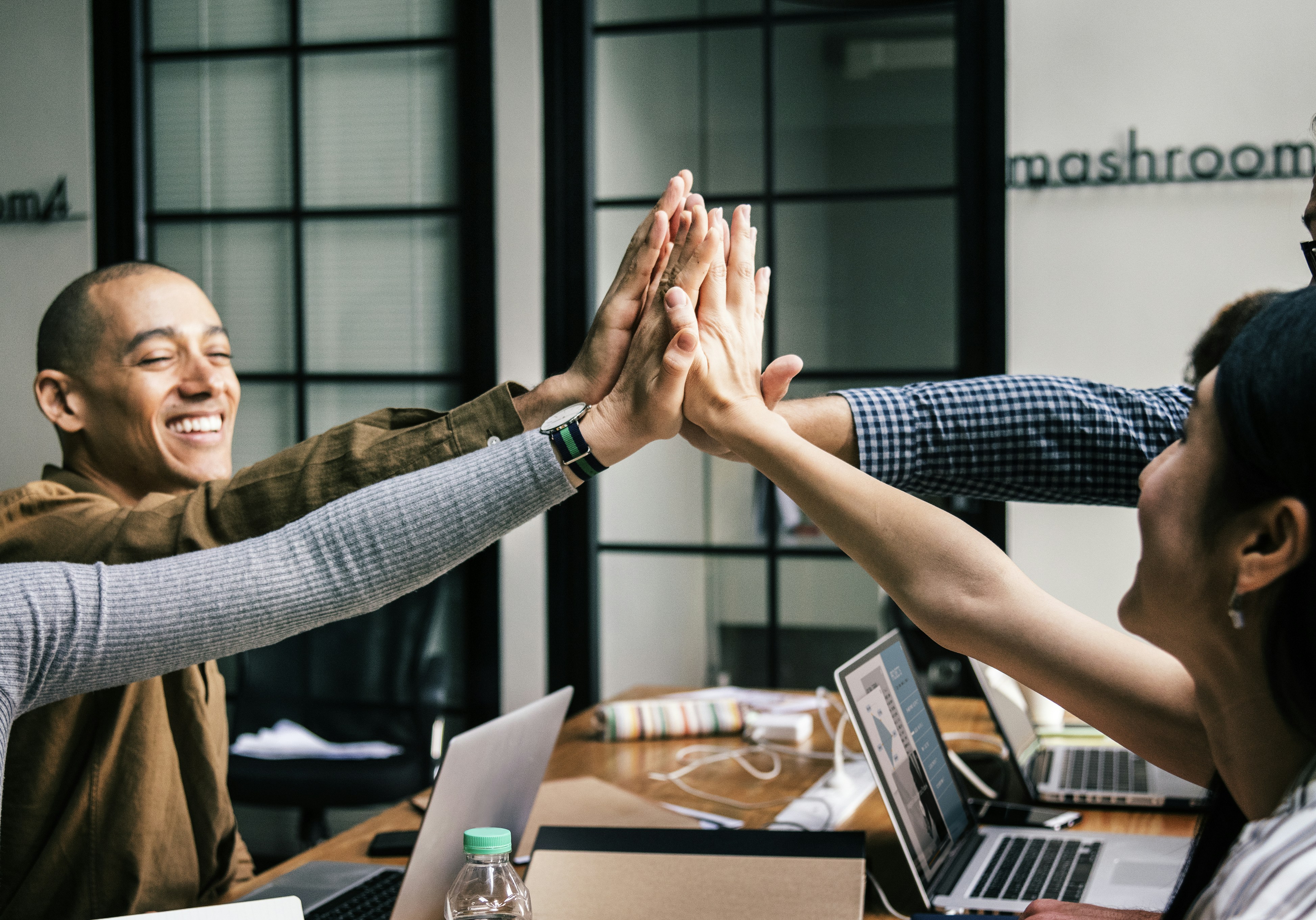 four people giving high fives at the same time