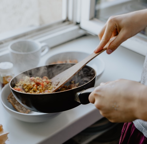 person holding black frying pan