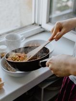 person holding black frying pan