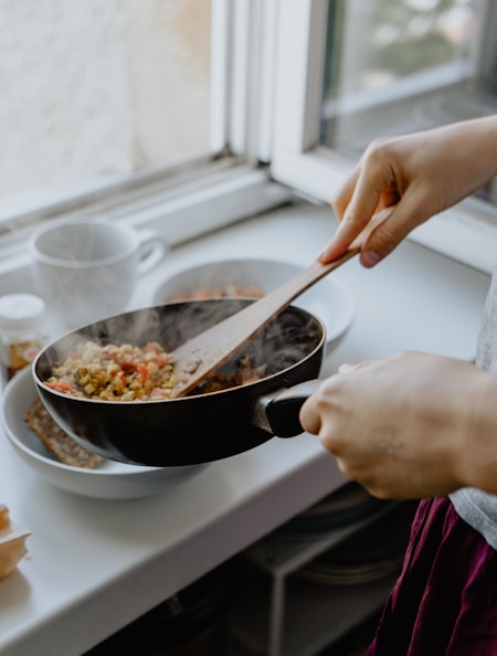 person holding black frying pan