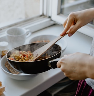 person holding black frying pan