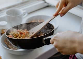 person holding black frying pan