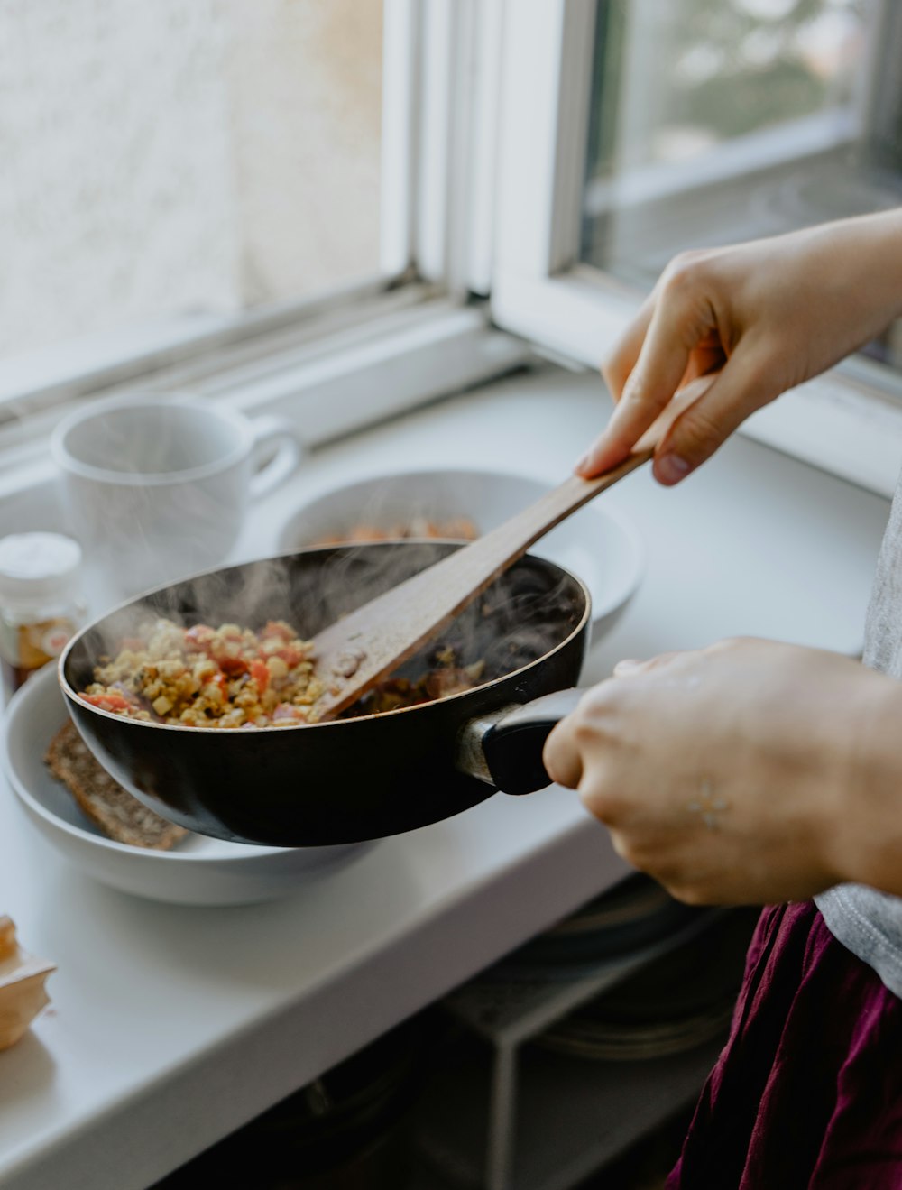 personne tenant une poêle à frire noire