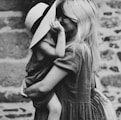 grayscale photography of woman carrying girl