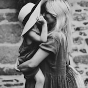 grayscale photography of woman carrying girl