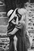 grayscale photography of woman carrying girl