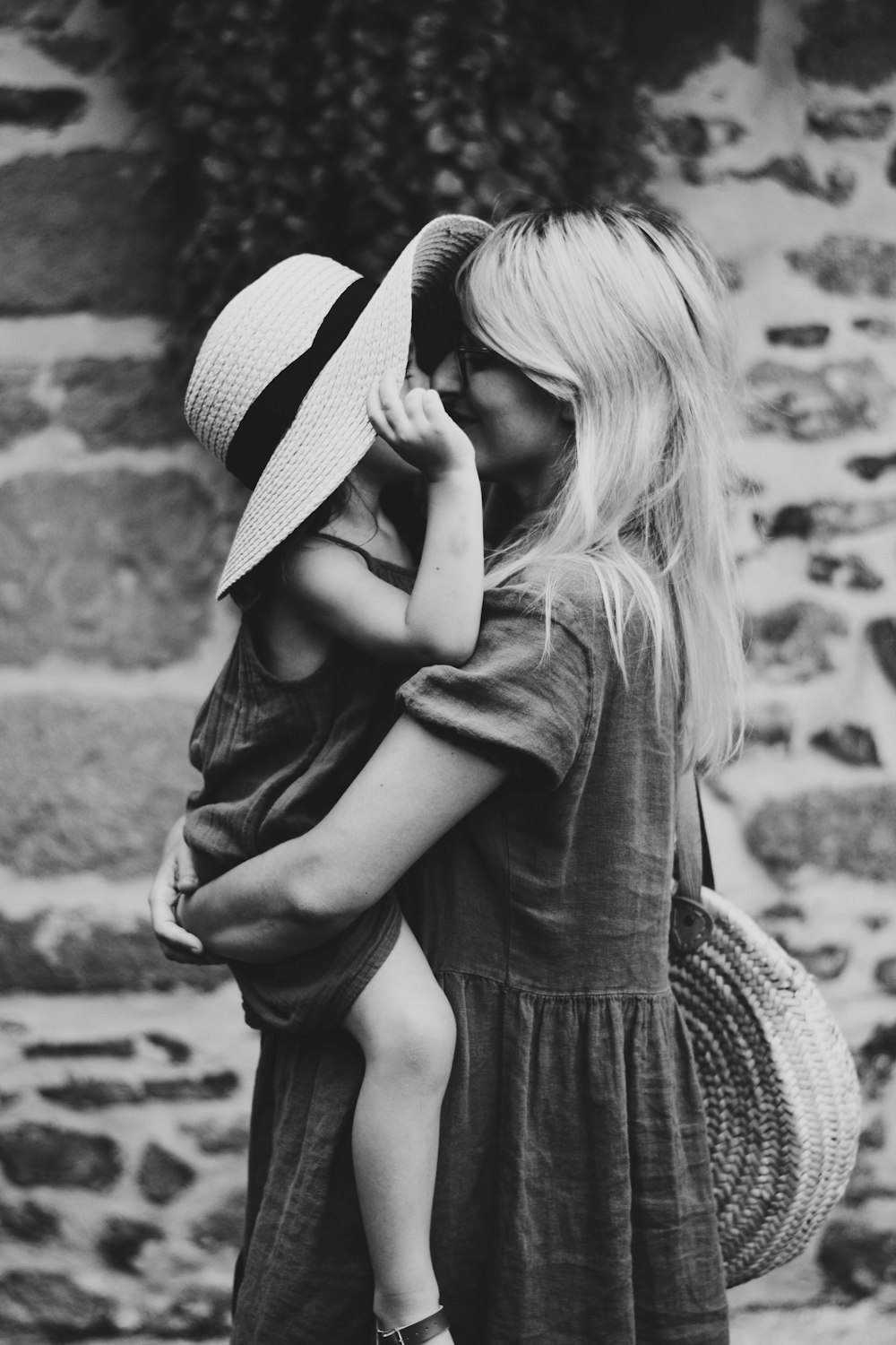 Fotografía en escala de grises de mujer cargando niña