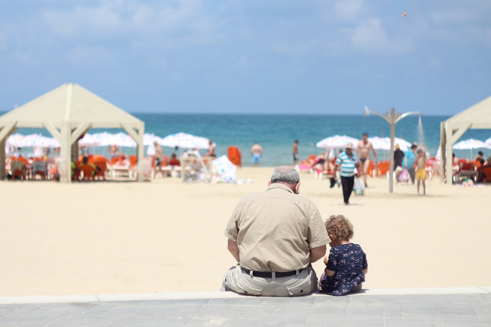 man sitting besides girl on bench