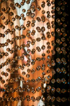 Close-up of purple and white handmade bead accessories glowing softly against a dark background.