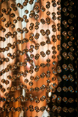 Close-up of purple and white handmade bead accessories glowing softly against a dark background.
