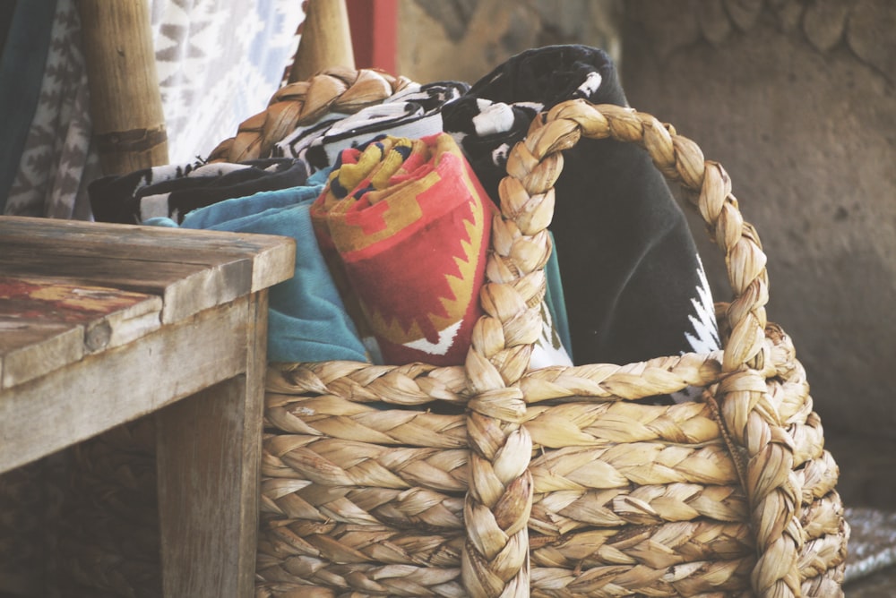 assorted rolled textiles on brown basket