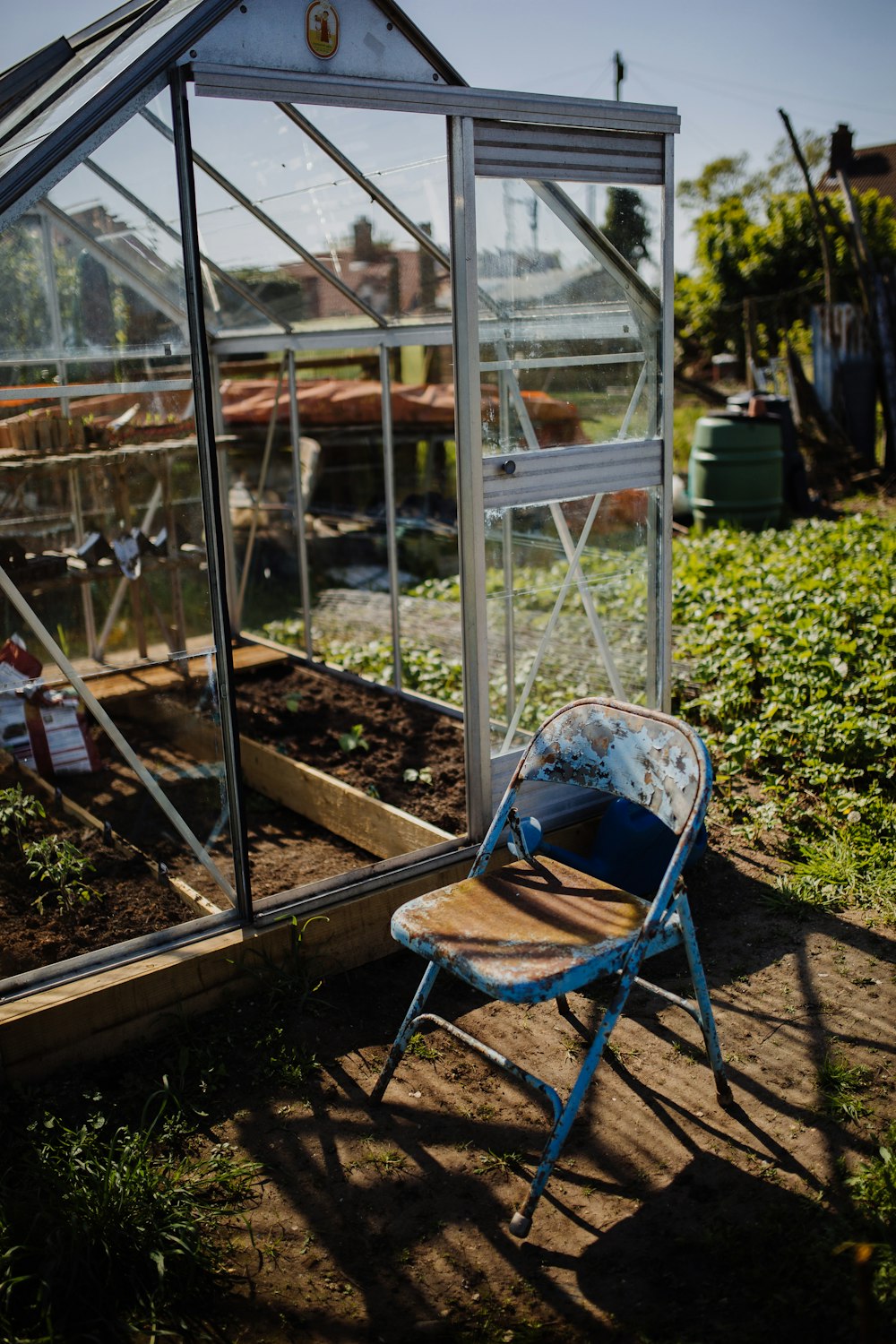 blue and brown steel folding chair beside greenhouse