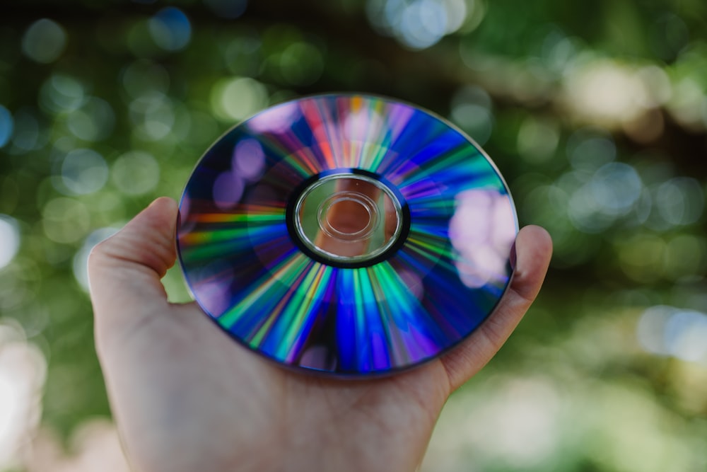 Photographie sélective de la personne tenant un disque compact