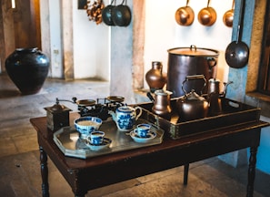 two assorted-color teapot set on top of table