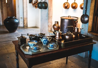 two assorted-color teapot set on top of table