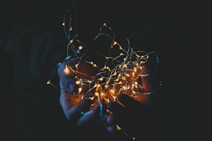 person holding string lights