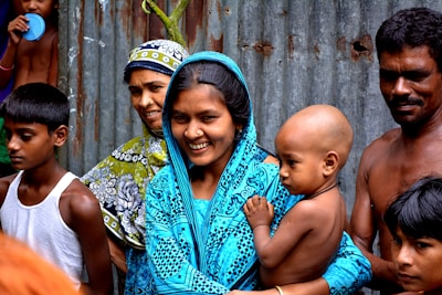 woman holding baby surrounded with people