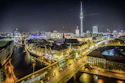 time-lapse photography of vehicle at the road in between the building at nighttime aerial photography