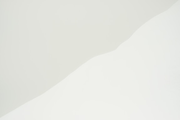 a man riding a snowboard down the side of a snow covered slope