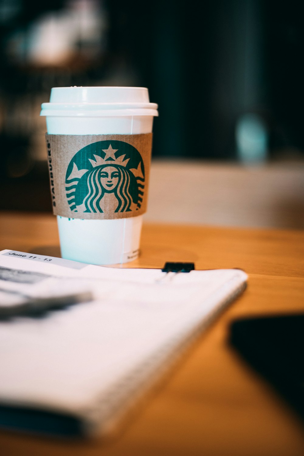 fotografia a fuoco selettiva della tazza di caffè Starbucks