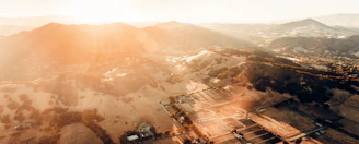 A panoramic view of a premium land plot in Tangier with golden sunlight highlighting the terrain.