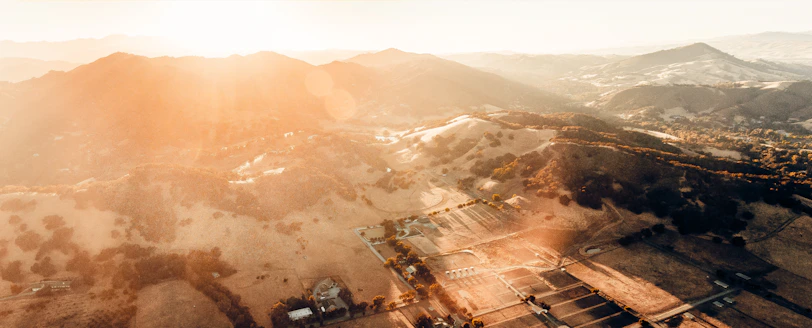 Aerial view of a freshly parceled land plot under golden sunlight.
