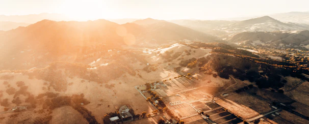 A panoramic view of a premium land plot in Tangier with golden sunlight highlighting the terrain.