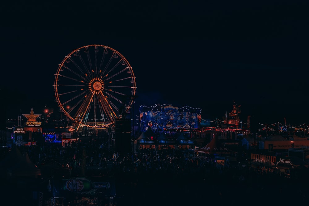 lighted Ferris wheel beside building