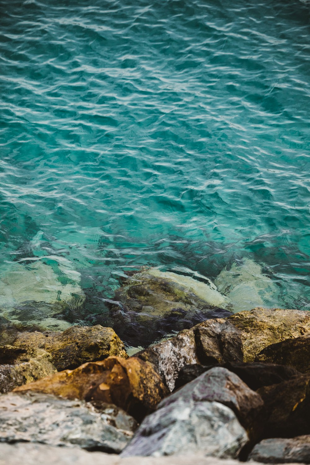 calm body of water near rock formation at daytime