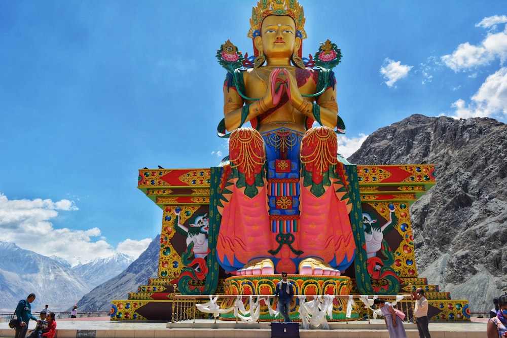 brown buddha statue in front of a mountain