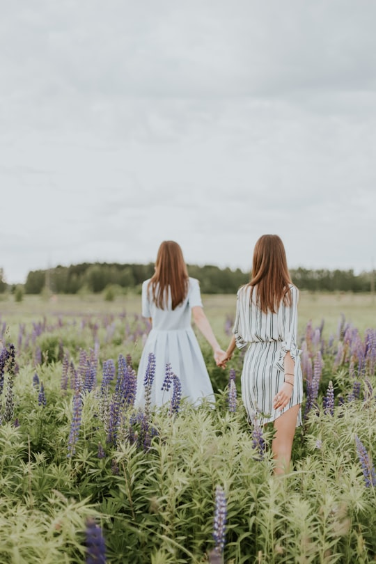 two women surrounded by lavender under nimbus clouds in Riga Latvia