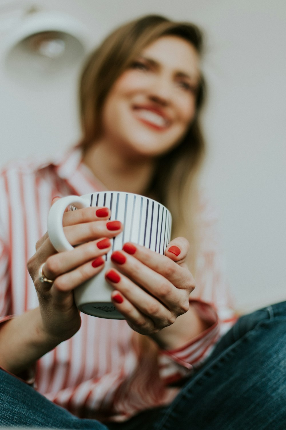 woman holding white and black ceramic mug