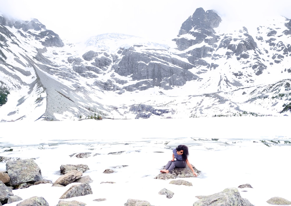 woman sitting on stone during winter at daytime