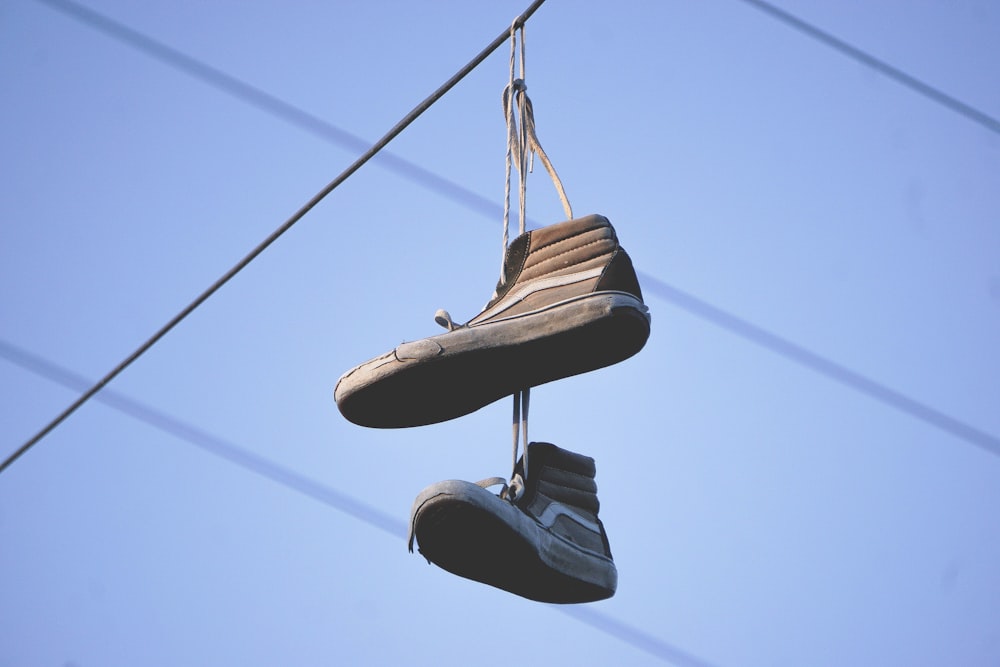 black-and-gray Vans Sk8-Hi sneakers hanged on electric wire