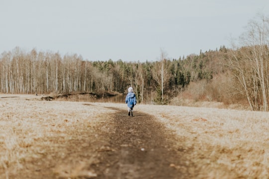 girl standing near trees during daytime in Sigulda Latvia