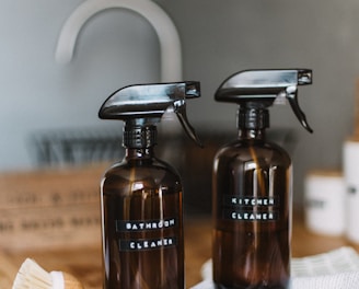 two brown spray bottles on brown table