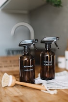 two brown spray bottles on brown table