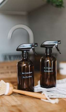 two brown spray bottles on brown table