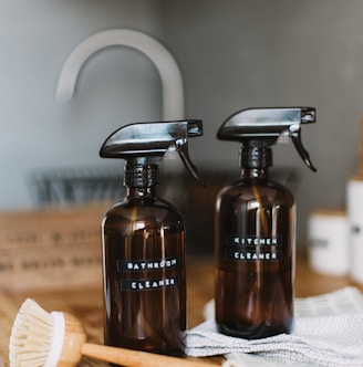 two brown spray bottles on brown table