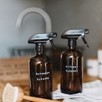 two brown spray bottles on brown table