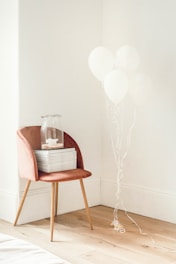 white balloons beside jar on book and chair