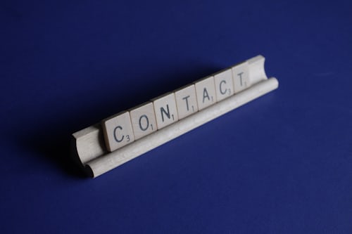 Scrabble tiles spelling the word CONTACT to represent how to reach out to companies on Instagram. 