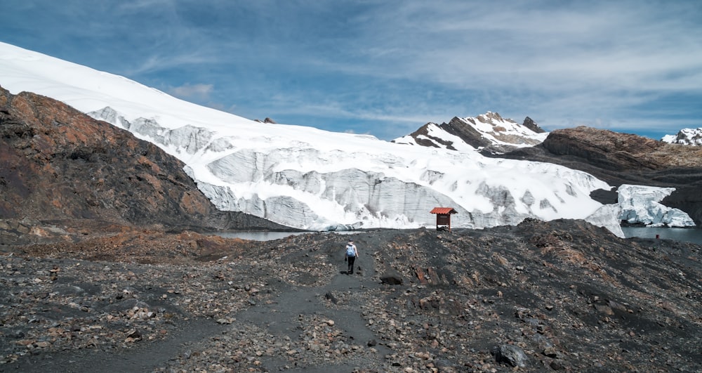 person walking at the hill during daytime