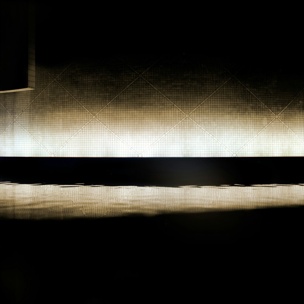 a black and white photo of a bench in the dark