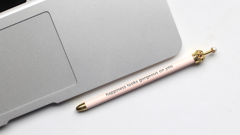 stylo blanc près de l’ordinateur portable gris