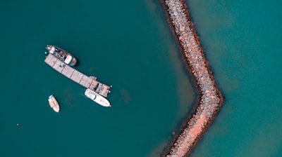 bird's eye view photography of boat near the coast drone view google meet background